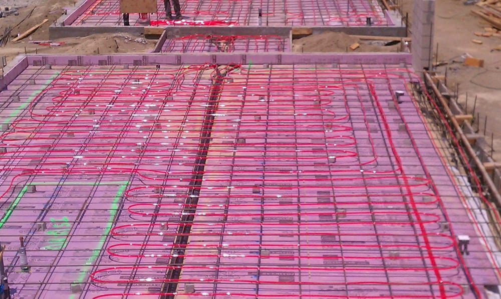 Construction site with visible red piping for underfloor heating installation by Duncan Plumbing Ent., Inc. in Santa Cruz.
